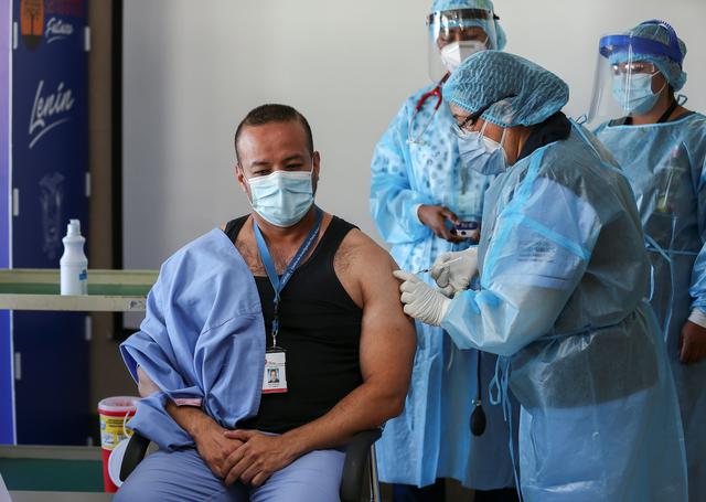 El doctor Jorge Luis Vélez recibe la vacuna contra el COVID-19 en el Hospital Centinela Pablo Arturo Suárez, Quito (Ecuador), el 21 de enero de 2021. (EFE/ Jose Jacome).