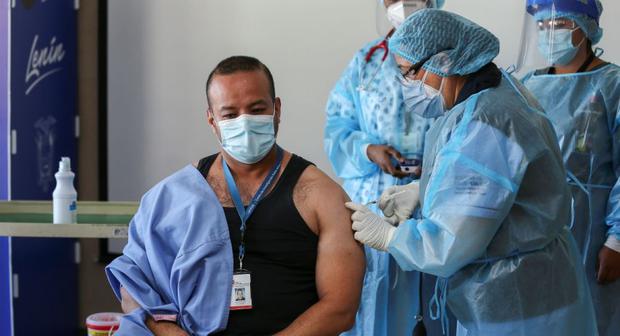 El doctor Jorge Luis Vélez recibe la vacuna contra el COVID-19 en el Hospital Centinela Pablo Arturo Suárez, en Quito (Ecuador). (EFE/ Jose Jacome). 