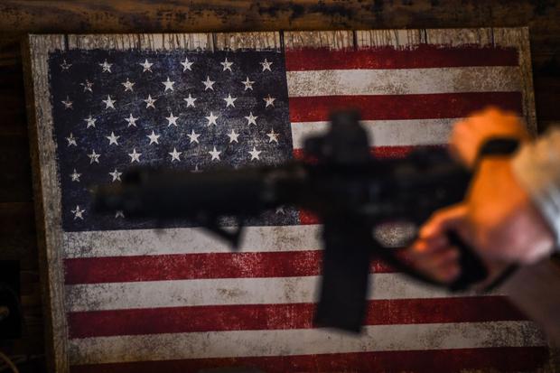 Un instructor enseña el manejo de rifles semiautomáticos AR-15 con una bandera de los Estados Unidos al fondo, en Jackson, Mississippi, el 26 de setiembre de 2020.  (CHANDAN KHANNA / AFP).